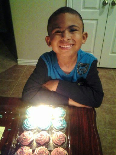 Jaiden smiling with birthday cupcakes